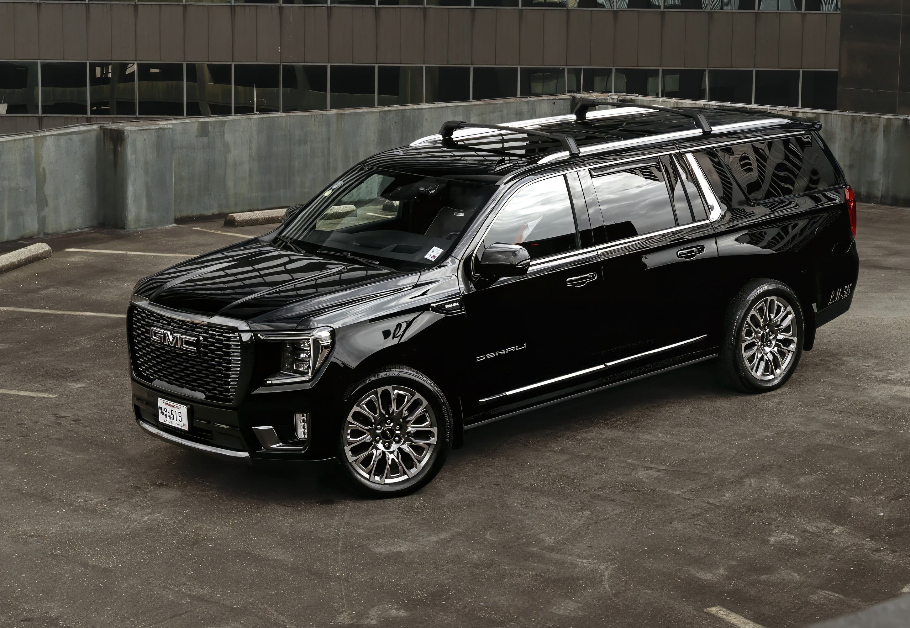 A black suv with a roof rack on the back of it.