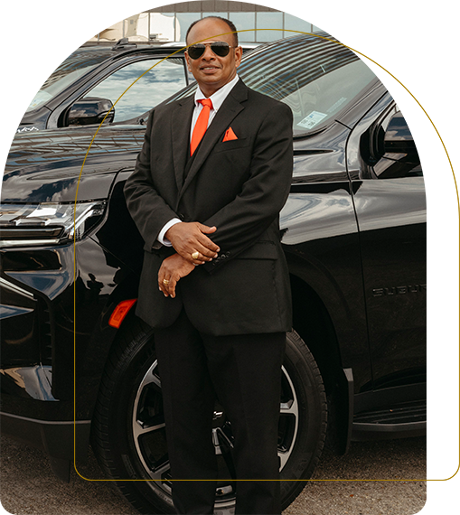 A man in a suit standing next to a car.